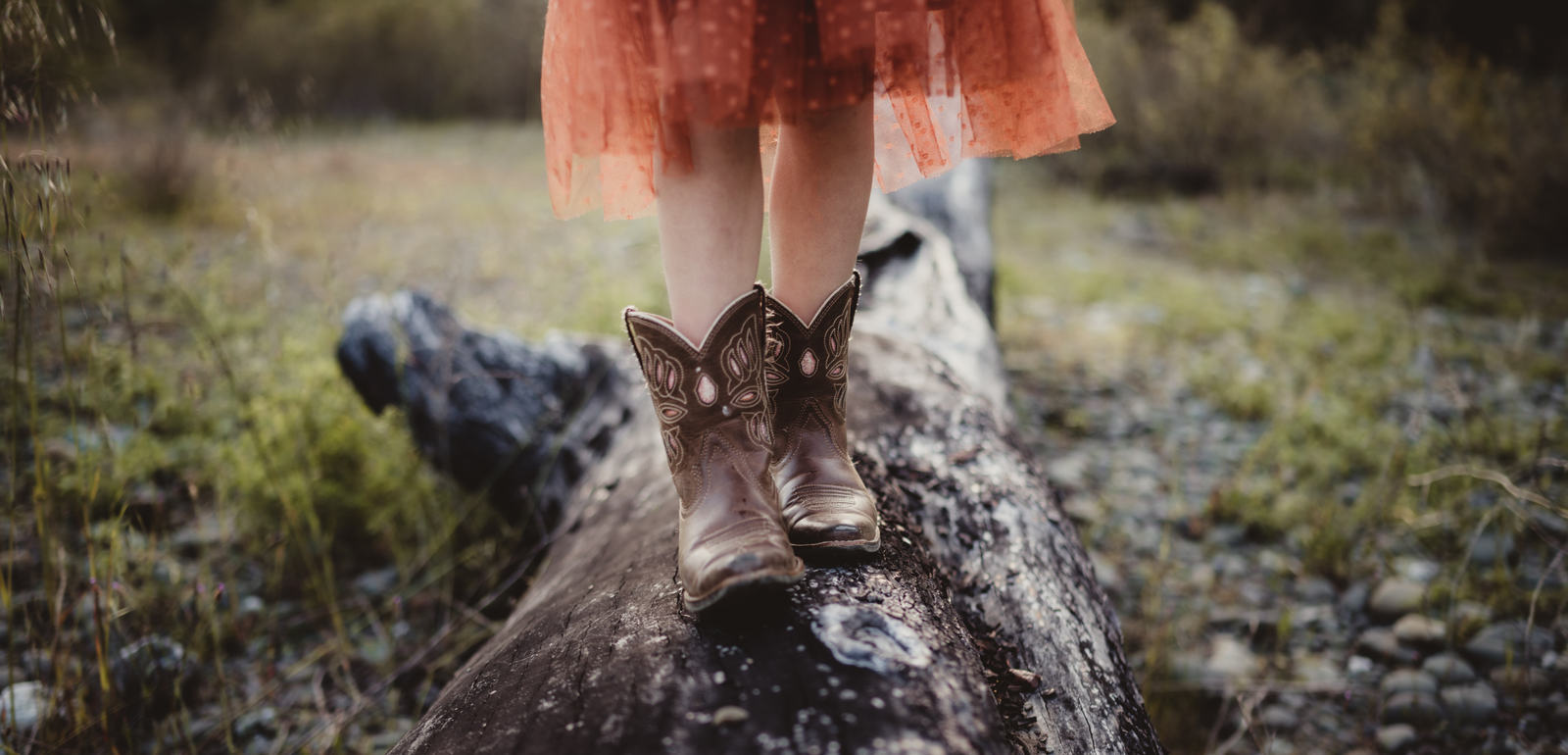 girl's feet balancing on wooden log outside