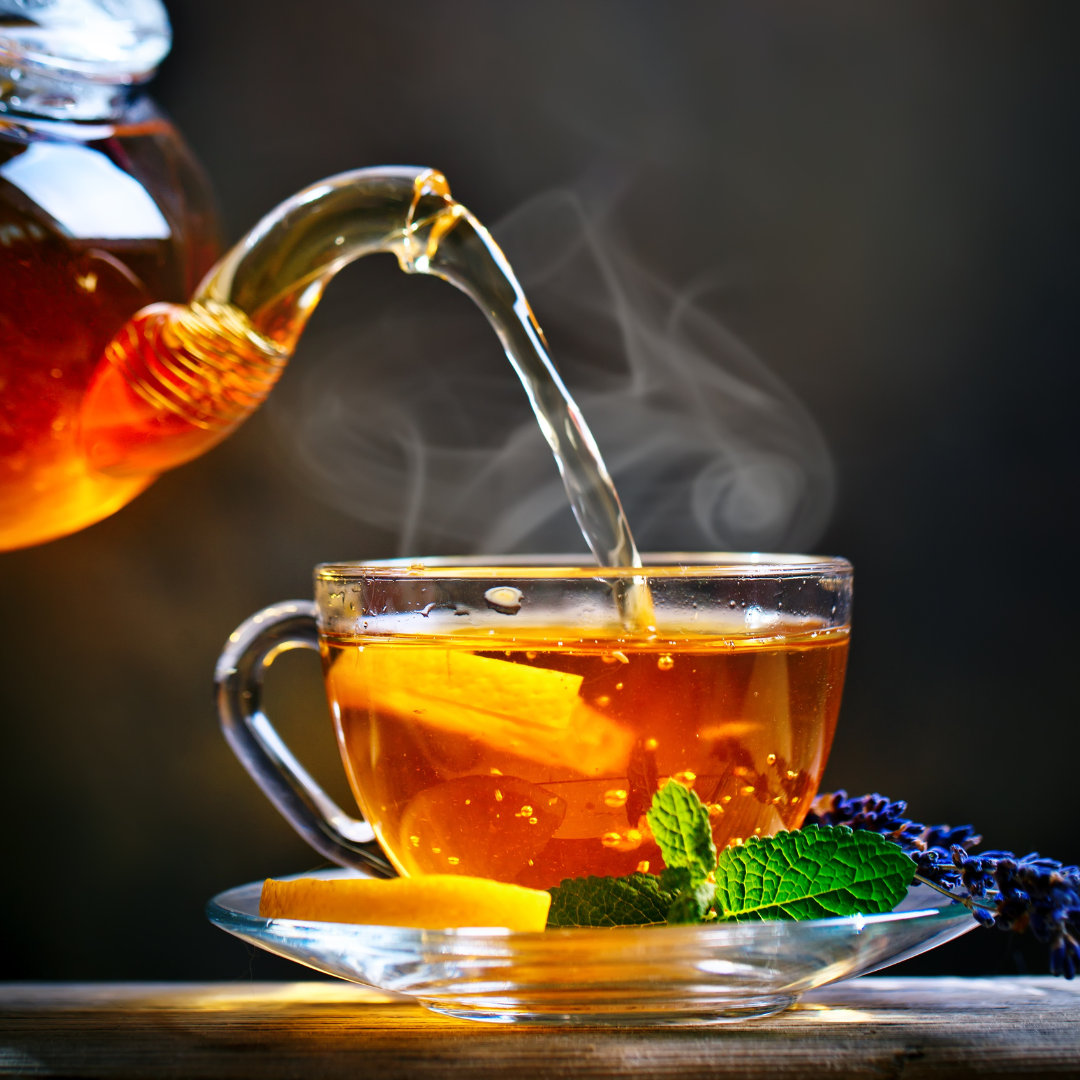 clear teapot with tea being poured into clear cup and saucer for mindful mornings challenge 