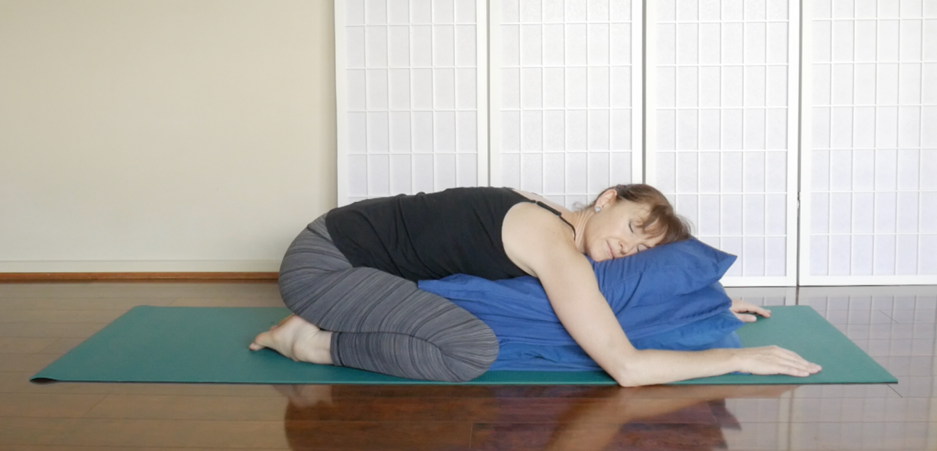 woman demonstrating restorative yoga version of fish pose