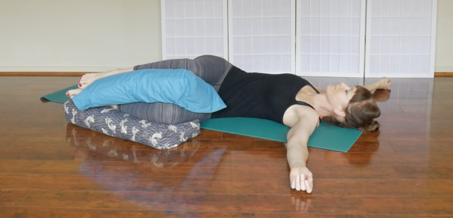 woman demonstrating restorative yoga version of fish pose